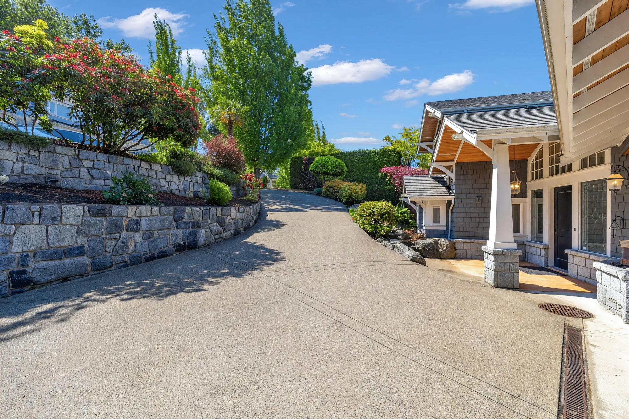 The drive running up between granite retaining walls and planted banks to the house