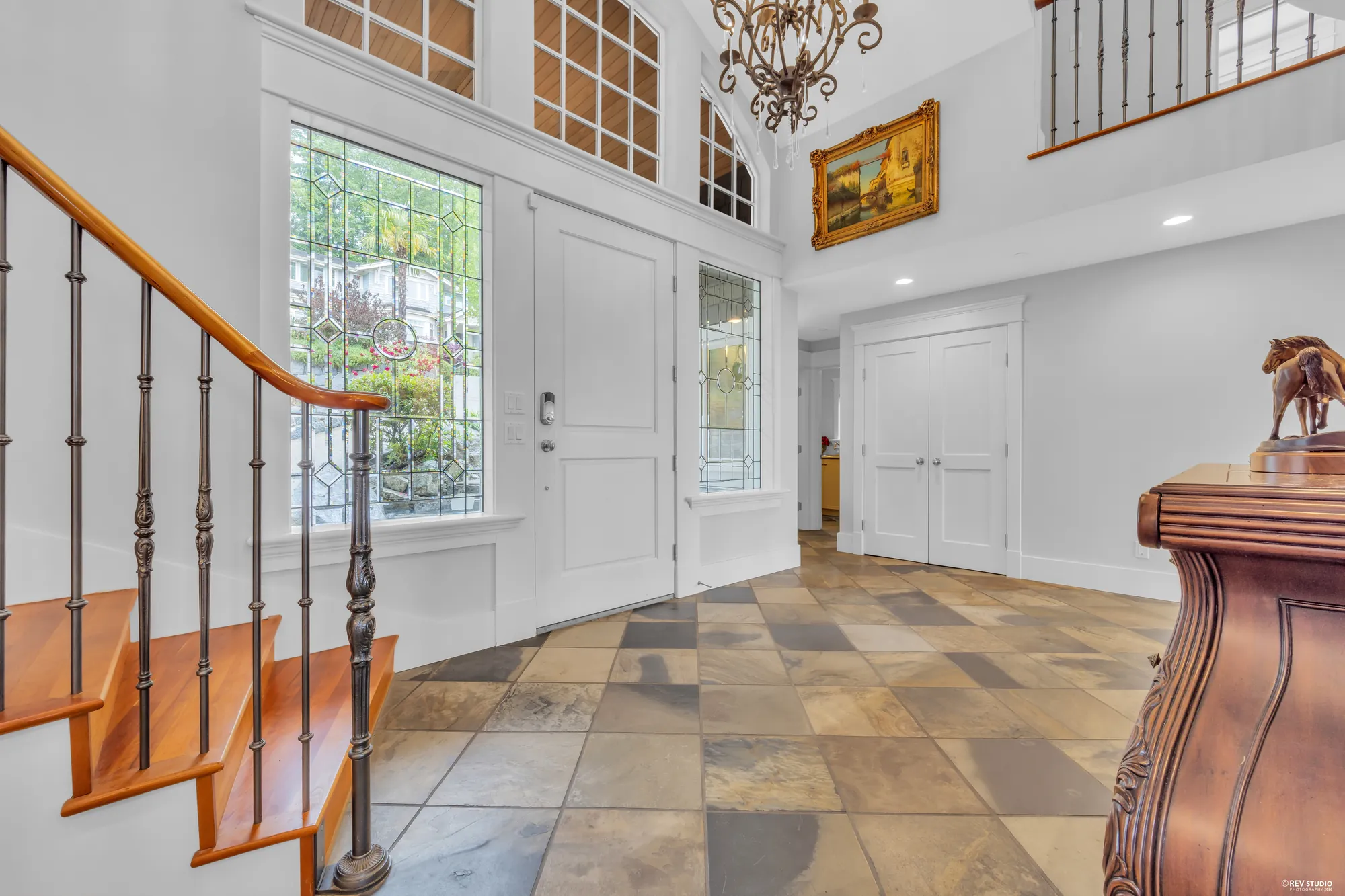 The front door from inside, the slate floor and the stair balustrade in wrought iron