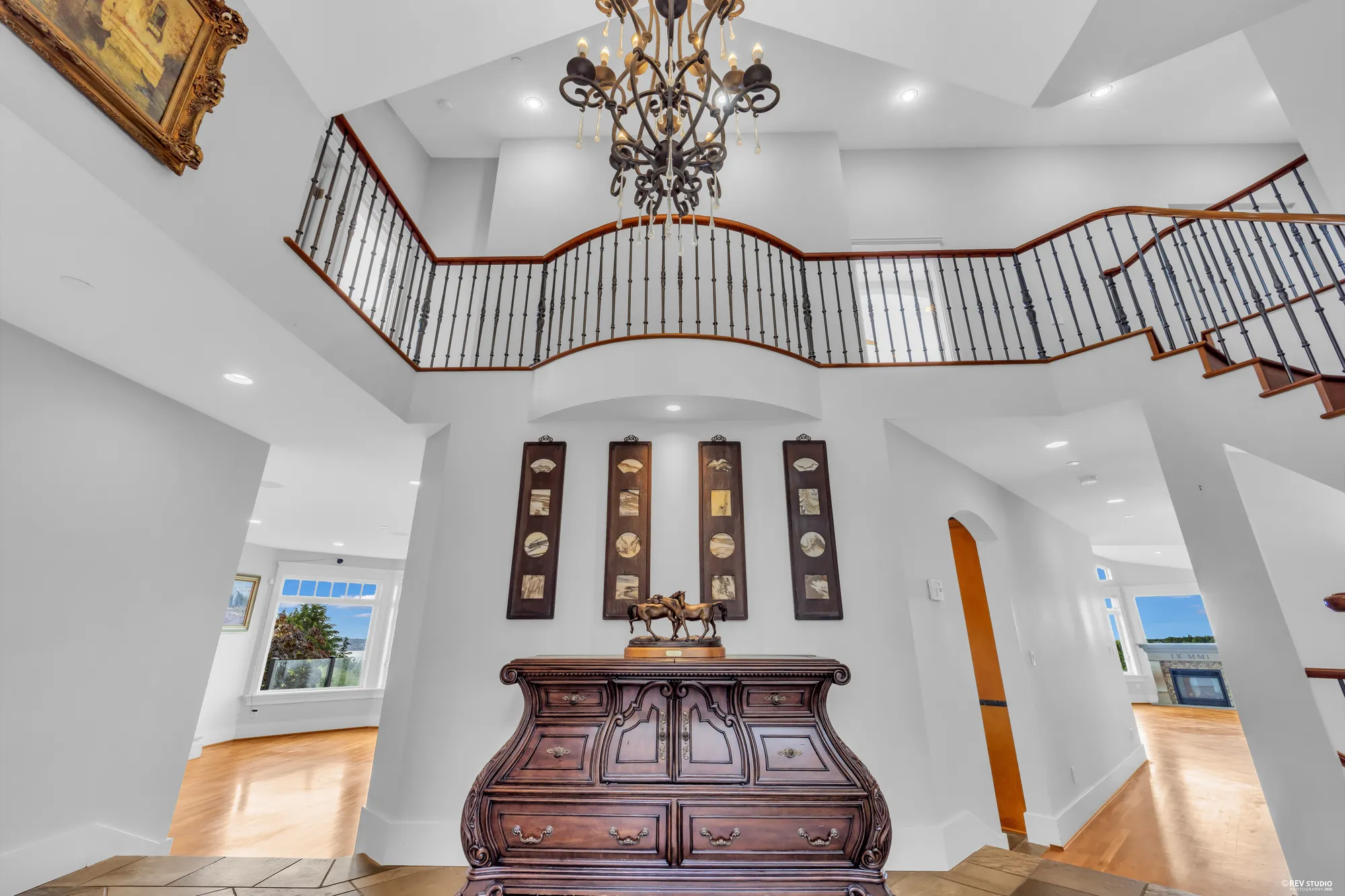 The two-storey entry from the landing above, the chandelier hanging in the middle of the void