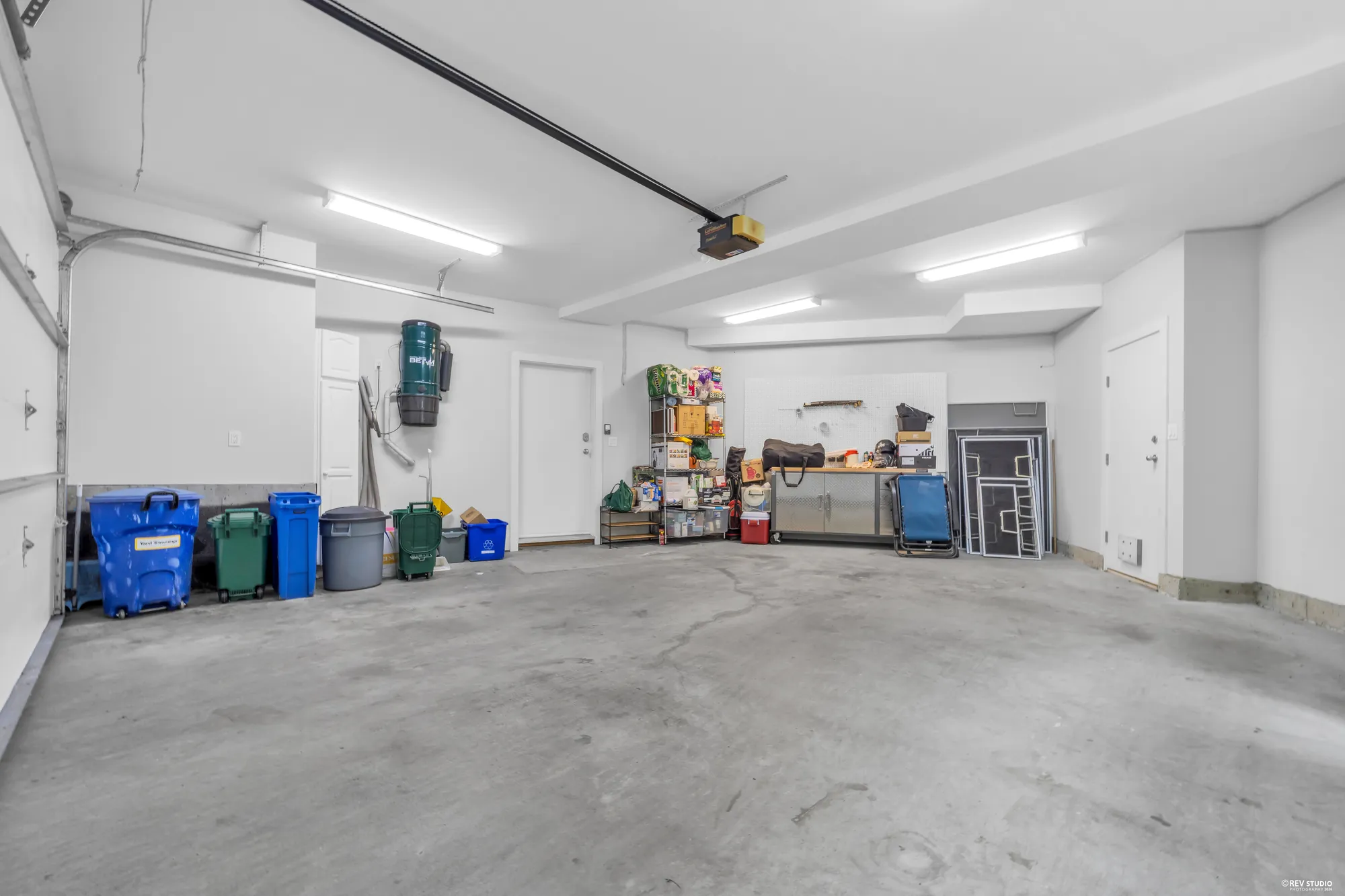 The garage from the far end, shelving down one side and the door through to the house