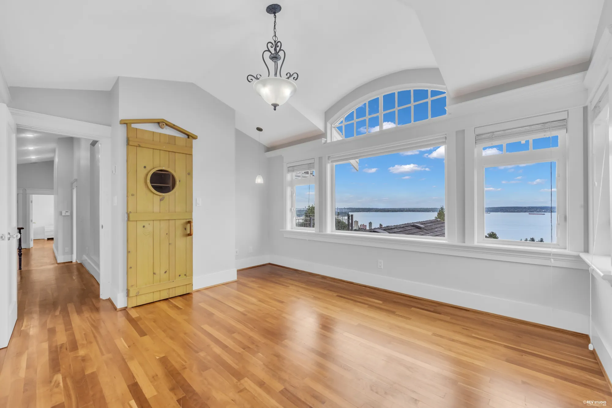 The upstairs hall past a yellow-painted door, the window bay at the end filled with water