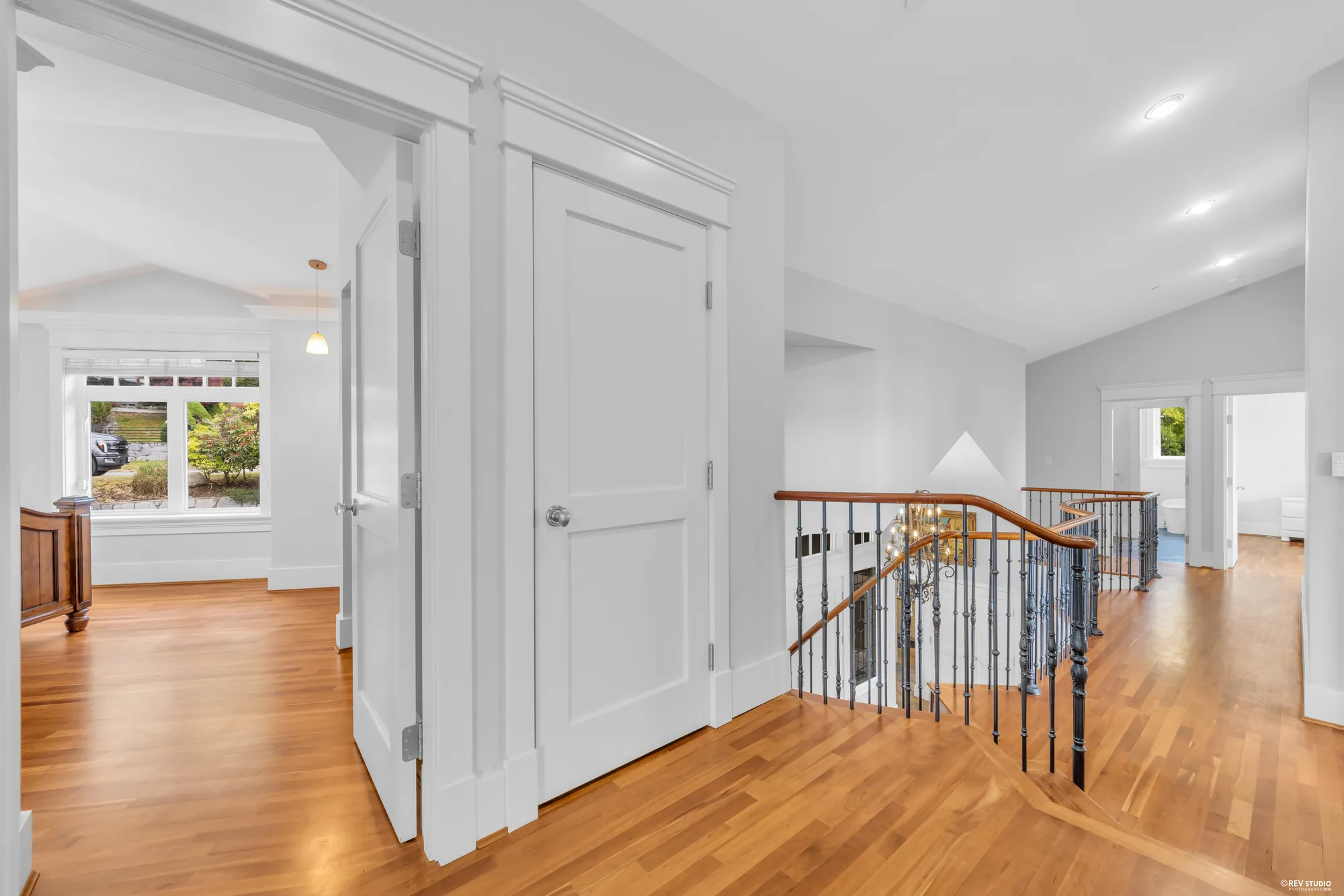 The upper landing with its wrought-iron balustrade looking down into the entry