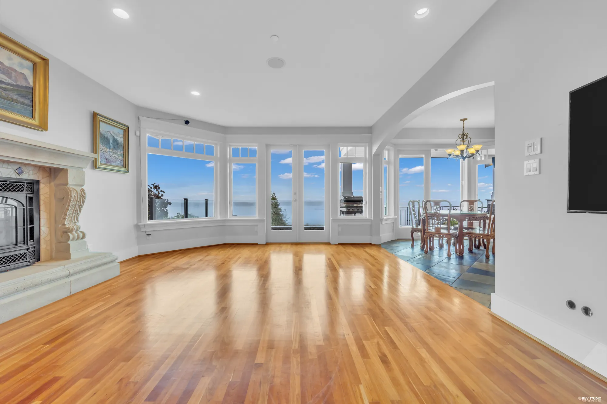 Living and dining read together in one frame, the fireplace at one end and the dining table beyond