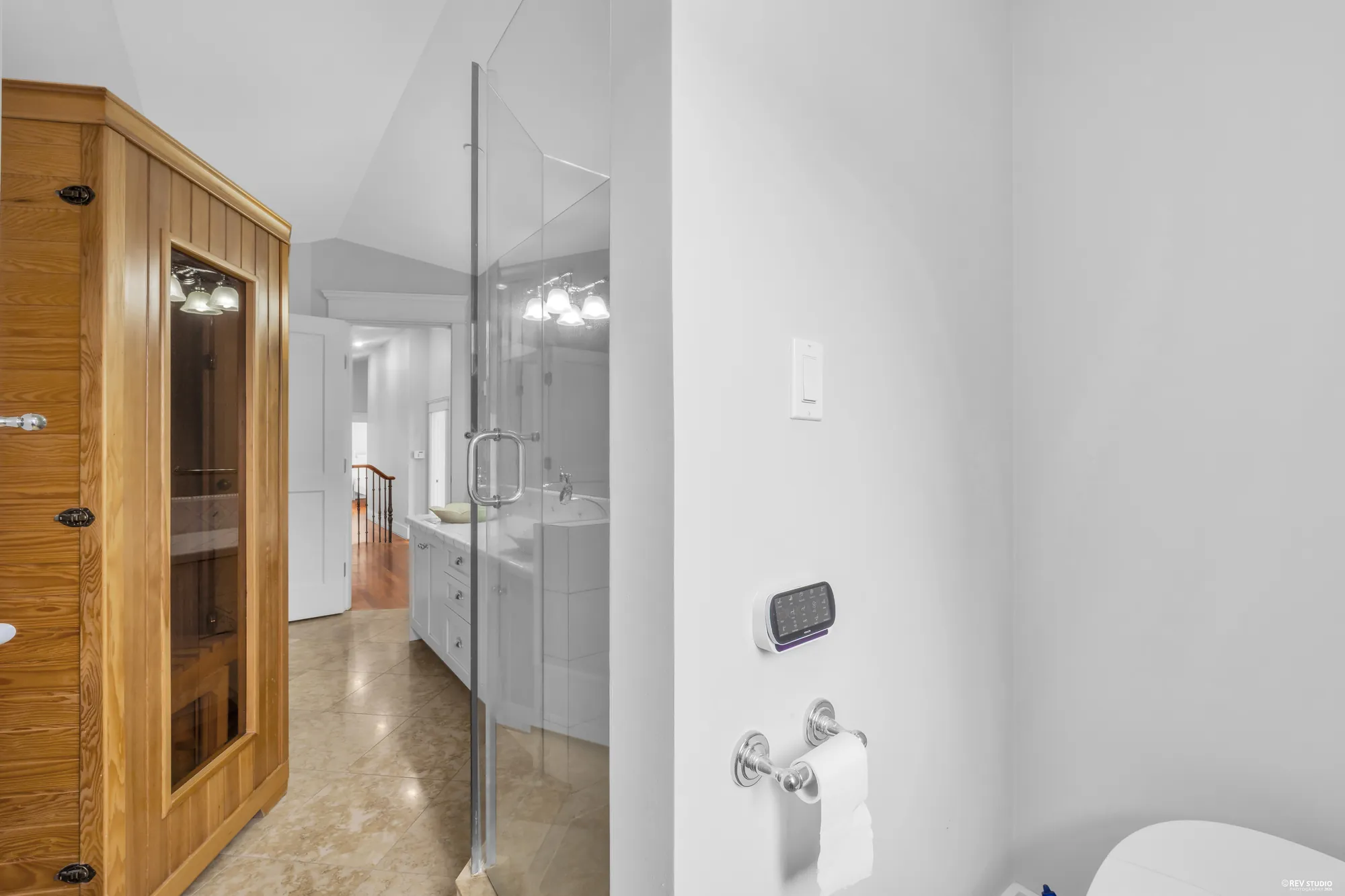 The same bathroom from the far side, the sauna door on the left and the vanity beyond